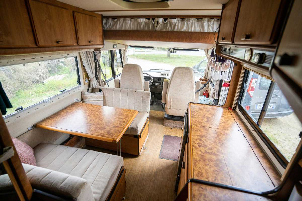 Famiglia accanto a un camper parcheggiato, con vista su Pienza e distese di colline, atmosfera al tramonto